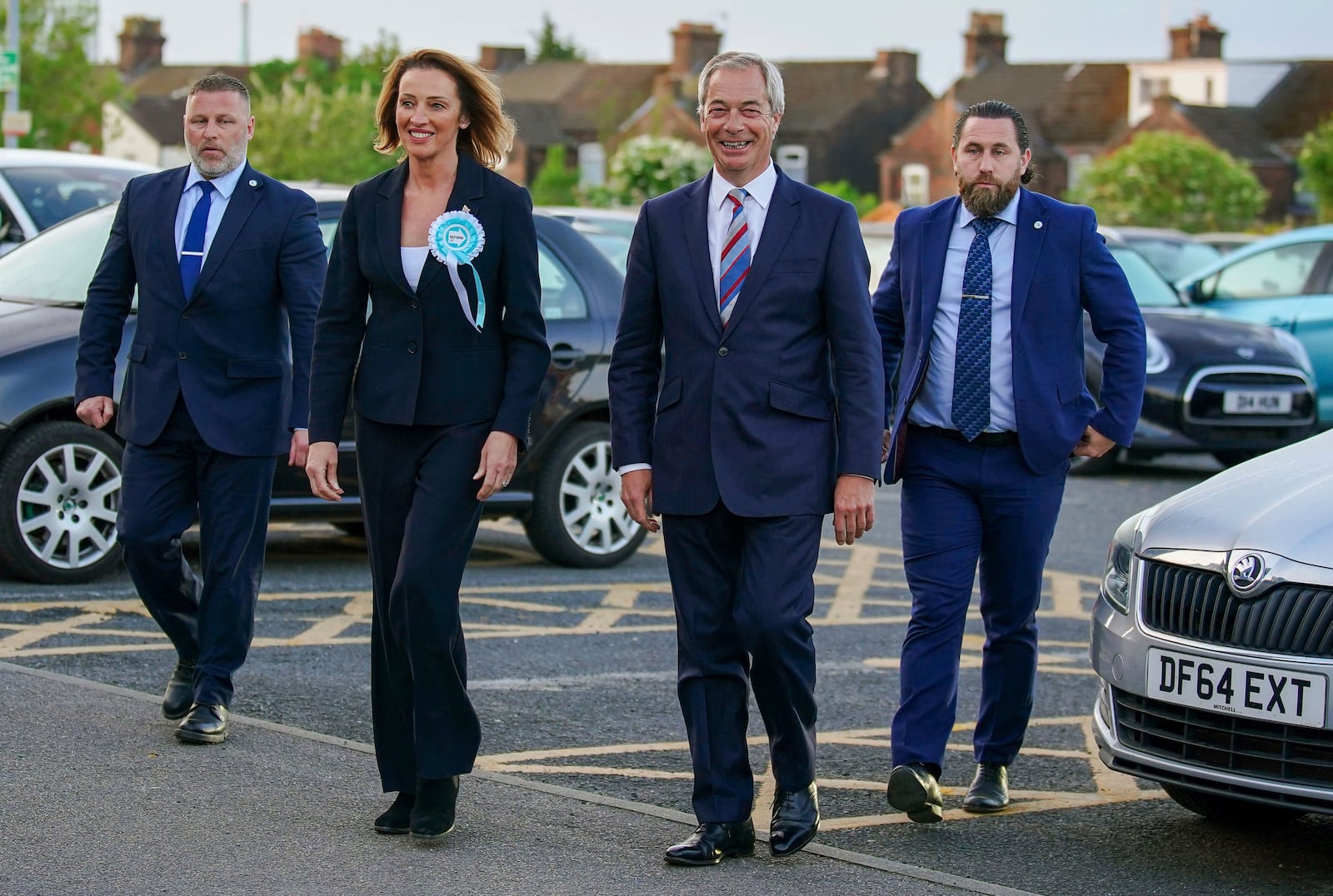 Reform UK candidate Sarah Pochin, second left and party leader Nigel Farage, second right, arrive at the DCBL Halton Stadium ahead of the result of the Runcorn and Helsby by-election at DCBL Halton Stadium, Widnes, Cheshire, Friday, May 2, 2025. (Peter Byrne/PA via AP)