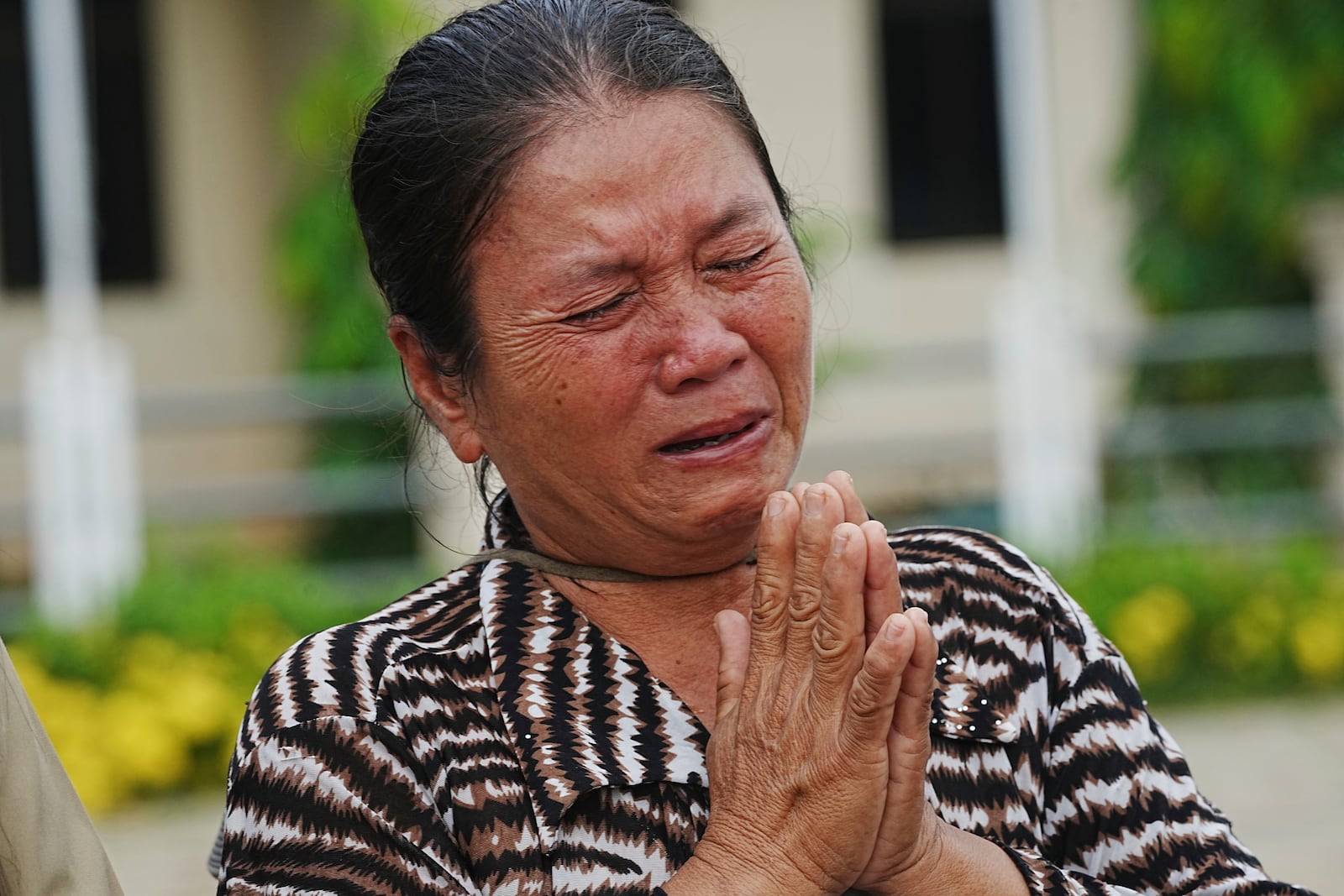 A local villager weeps as she donates her personal belongings for the frontline army force at a sidewalk in Srey Snam district in Siem Reap province, Cambodia, Saturday, July 26, 2025. (AP Photo/Heng Sinith)