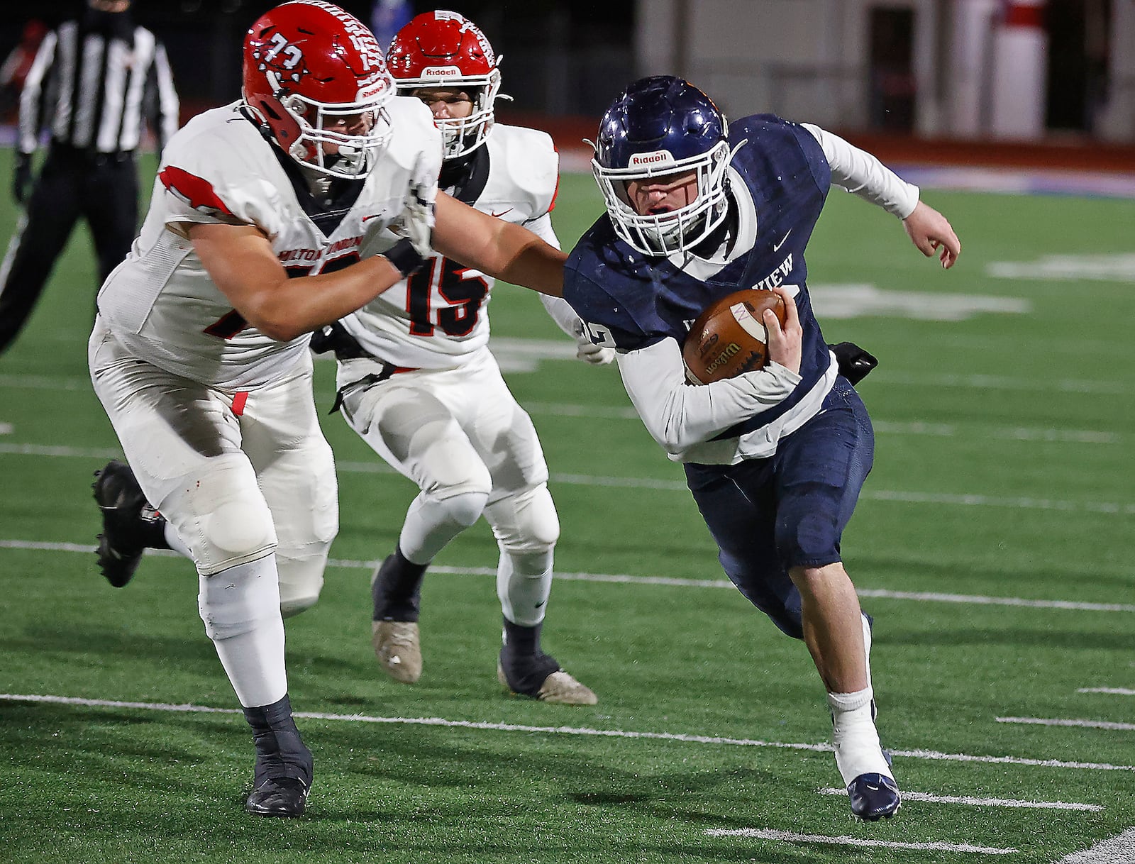 Valley View's Jake Clark tries to avoid a tackle by Milton Union's Ethan Lane as he carries the ball. BILL LACKEY/STAFF