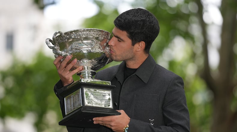 Carlos Alcaraz of Spain kisses the Norman Brookes Challenge Cup the morning after defeating Novak Djokovic of Serbia in the men's singles final at the Australian Open tennis championship, in Melbourne, Australia, Monday, Feb. 2, 2026. (AP Photo/Dita Alangkara)