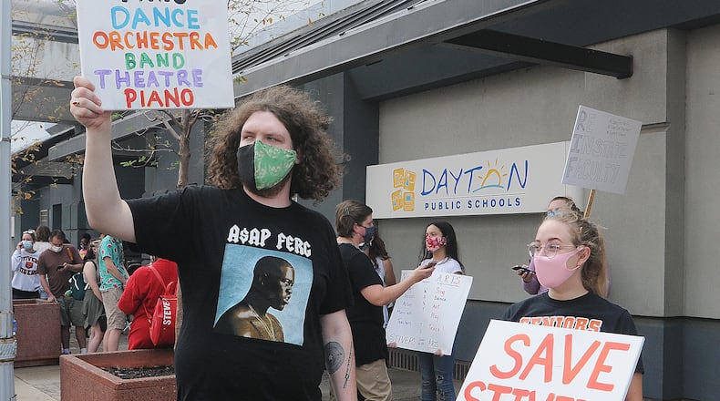A crowd of people protest layoffs of teachers outside the Dayton Public Schools headquarters building on Ludlow Street Friday. MARSHALL GORBY\STAFF
