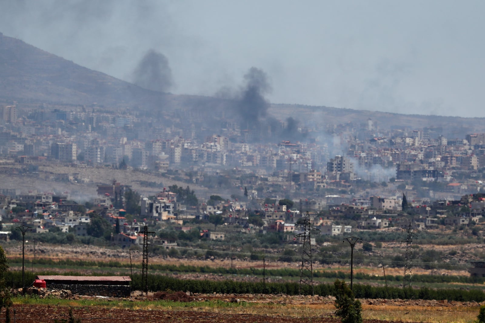 Smoke rise from clashes between Syrian government forces and Druze militias in Sweida city, southern Syria, Tuesday, July 15, 2025. (AP Photo/Omar Sanadiki)
