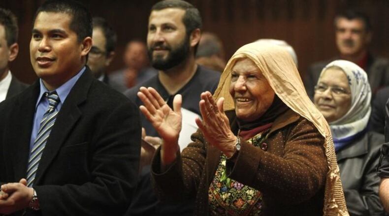 People celebrate after a ceremony and the oath of citizenship from U.S. District Judge Walter H. Rice during a naturalization ceremony in 2012. STAFF PHOTO