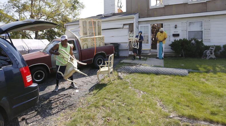 Friends move furniture of a tornado victim in Trotwood. Repairs are underway or waiting for insurance settlements in communities throughout the Dayton area one month after the Memorial Day tornadoes tore through many neighborhoods. TY GREENLEES / STAFF