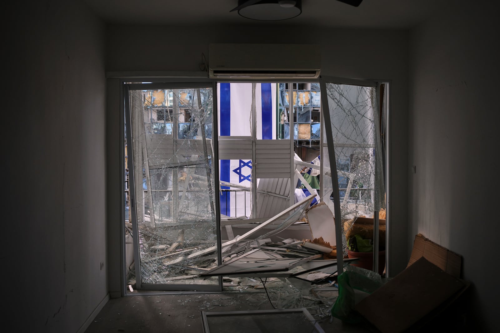 An Israeli flag is hung outside a damaged apartment two days after it was struck by a missile launched from Iran, in Ramat Gan, Israel, on Saturday, June 21, 2025. (AP Photo/Ohad Zwigenberg)