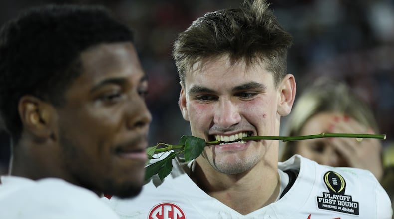 Alabama' Ty Simpson, right, and Germie Bernard celebrate a win after the first round of an NCAA College Football Playoff against Oklahoma, Saturday, Dec. 20, 2025, in Norman, Okla. (AP Photo/Nate Billings)