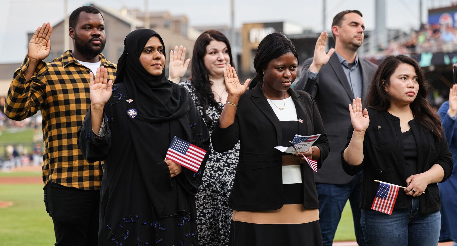 Nineteen immigrants became U.S. citizens during a naturalization ceremony on Tuesday, Aug. 5, between innings during a Dayton Dragons game at Day Air Ballpark. BRYANT BILLING / STAFF