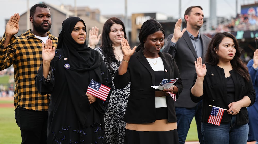 Nineteen immigrants became U.S. citizens during a naturalization ceremony on Tuesday, Aug. 5, between innings during a Dayton Dragons game at Day Air Ballpark. BRYANT BILLING / STAFF