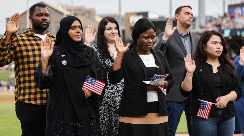 Twenty immigrants became U.S. citizens during a naturalization ceremony on Tuesday, Aug. 5, between the third and fourth innings during a Dayton Dragons game at Day Air Ballpark. BRYANT BILLING / STAFF