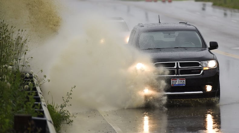 A vehicle drives through water on Liberty Way in Liberty Twp. in mid-July. NICK GRAHAM/STAFF