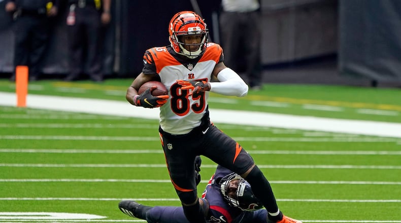 Cincinnati Bengals wide receiver Tee Higgins (85) catches a pass as Houston Texans inside linebacker Zach Cunningham reaches to tackle him during the first half of an NFL football game Sunday, Dec. 27, 2020, in Houston. (AP Photo/Eric Christian Smith)