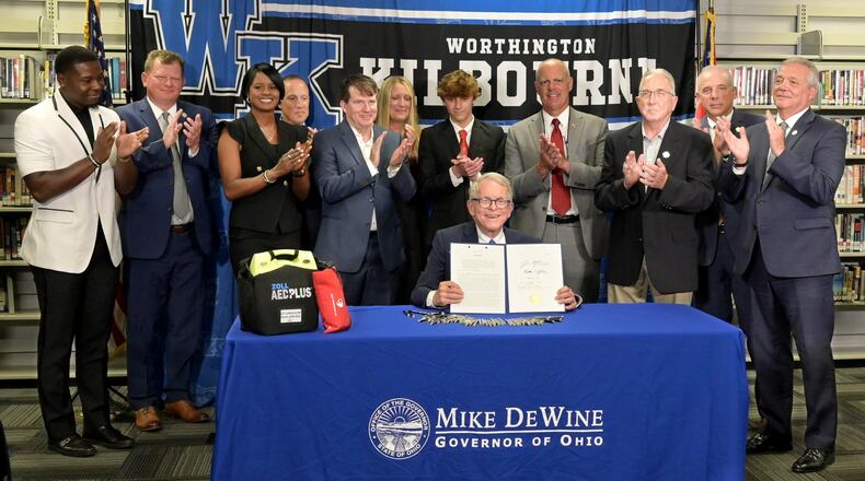 Ohio Gov. Mike DeWine shows off the signed House Bill 47, which will require all public and private schools to have AEDs on site as well as community centers. Contributed