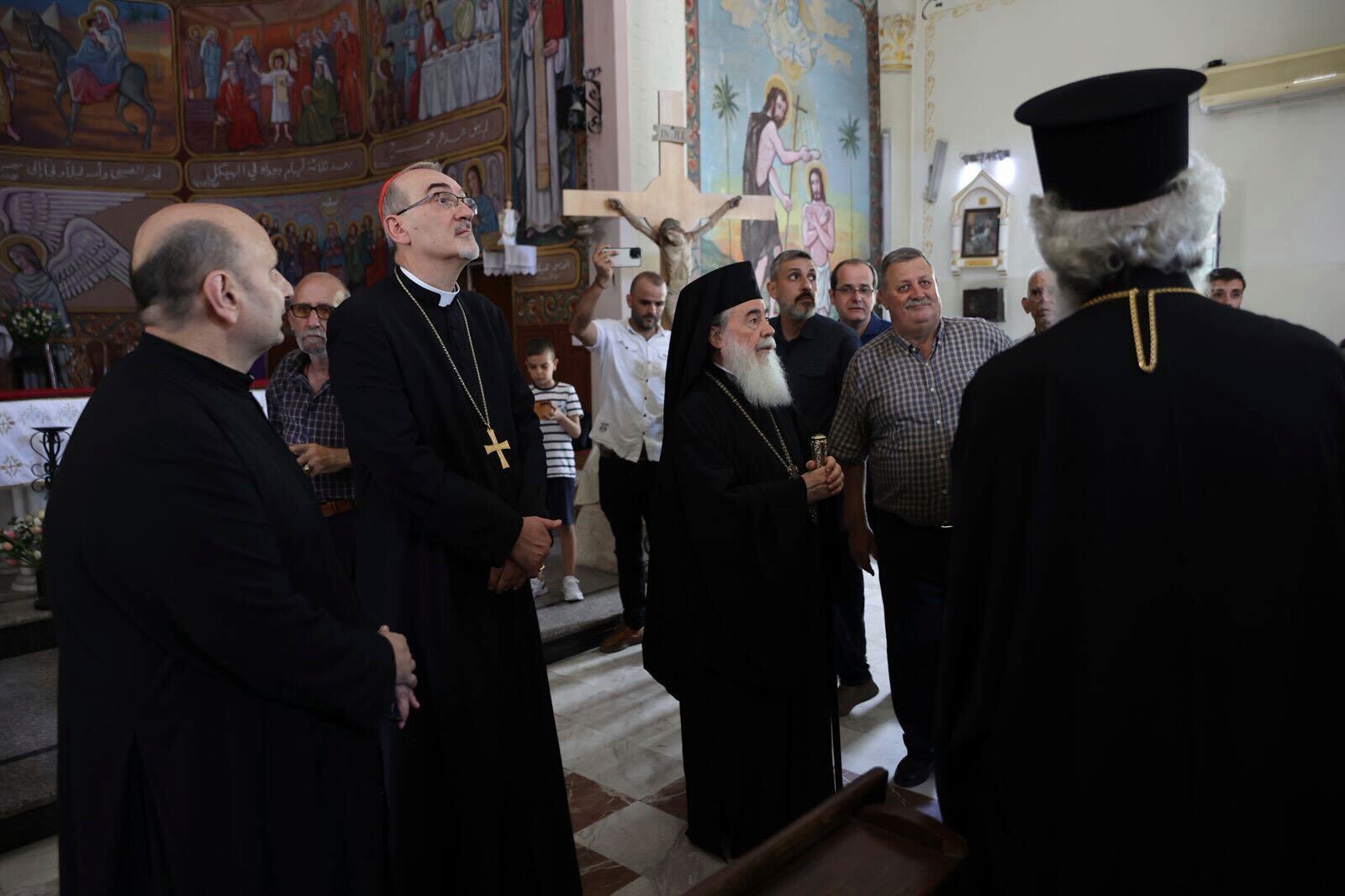 Patriarchs from Jerusalem, Latin Patriarch Cardinal Pierbattista Pizzaballa, second left, and Greek Orthodox Patriarch Theophilos III, center, lead a religious delegation to the Gaza Strip at the Holy Family Catholic Church, struck by an Israeli shell the day before in Deir al-Balah, Friday, July 18, 2025. (Latin Patriarchate of Jerusalem via AP)