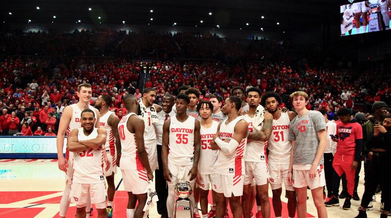 The Dayton Flyers pose with the Atlantic 10 Conference championship trophy after a victory against George Washington on March 7, 2020, at UD Arena. David Jablonski/Staff