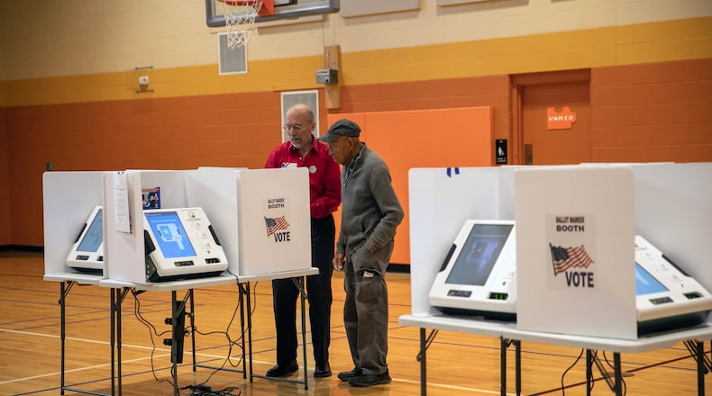 A poll worker, left, assists a voter at a polling place set up inside the Driving Park Community Center in Columbus, Ohio, on Election Day, Nov. 7, 2023. Voters headed to the polls in several states on Tuesday as this off-year election culminates with some key races on the line for Democrats and Republicans. (Maddie McGarvey/The New York Times)