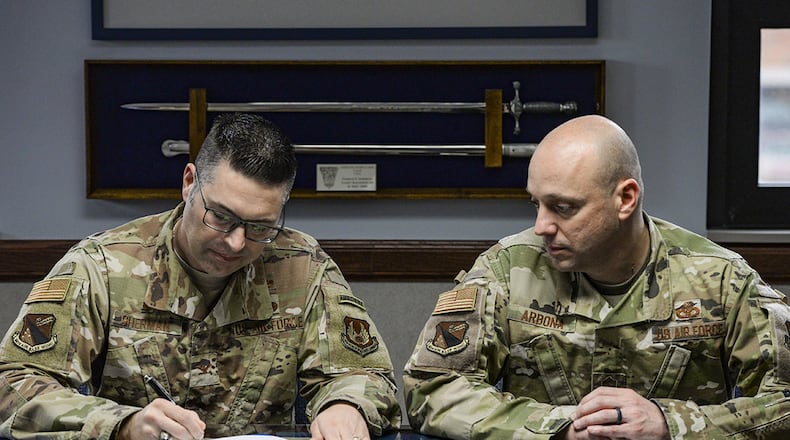 Col. Thomas Sherman, 88th Air Base Wing commander, signs the Asian American Pacific Islander Heritage Month Proclamation as Chief Master Sgt. Stephen Arbona, 88th ABW command chief, watches inside his office at Wright-Patterson Air Force Base, May 8. (U.S. Air Force photo/Wesley Farnsworth)