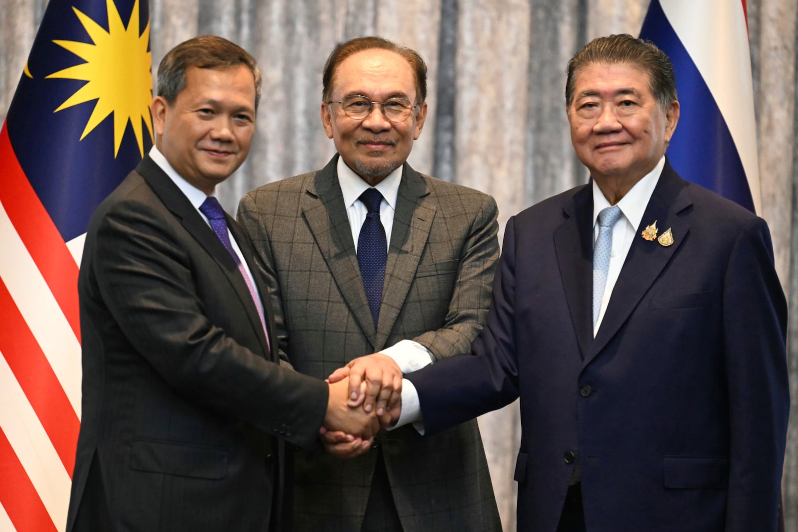 Malaysia's Prime Minister Anwar Ibrahim, center, Cambodia's Prime Minister Hun Manet left and Thailand's acting Prime Minister Phumtham Wechayachai pose for photos after talks on a possible ceasefire between Thailand and Cambodia in Putrajaya, Malaysia, Monday, July 28, 2025. (Mohd Rasfan/Pool Photo via AP)