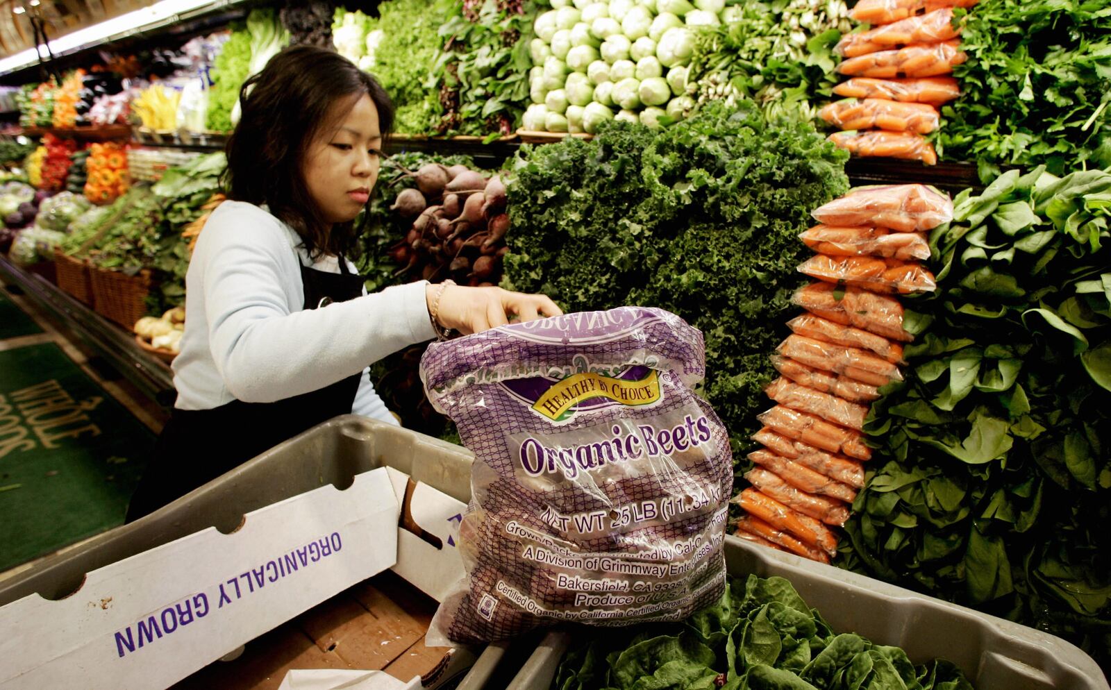 Ming Yee stocks shelves in the organic produce section 05 January, 2006 at the Whole Foods Market in Willowbrook, Illinois.