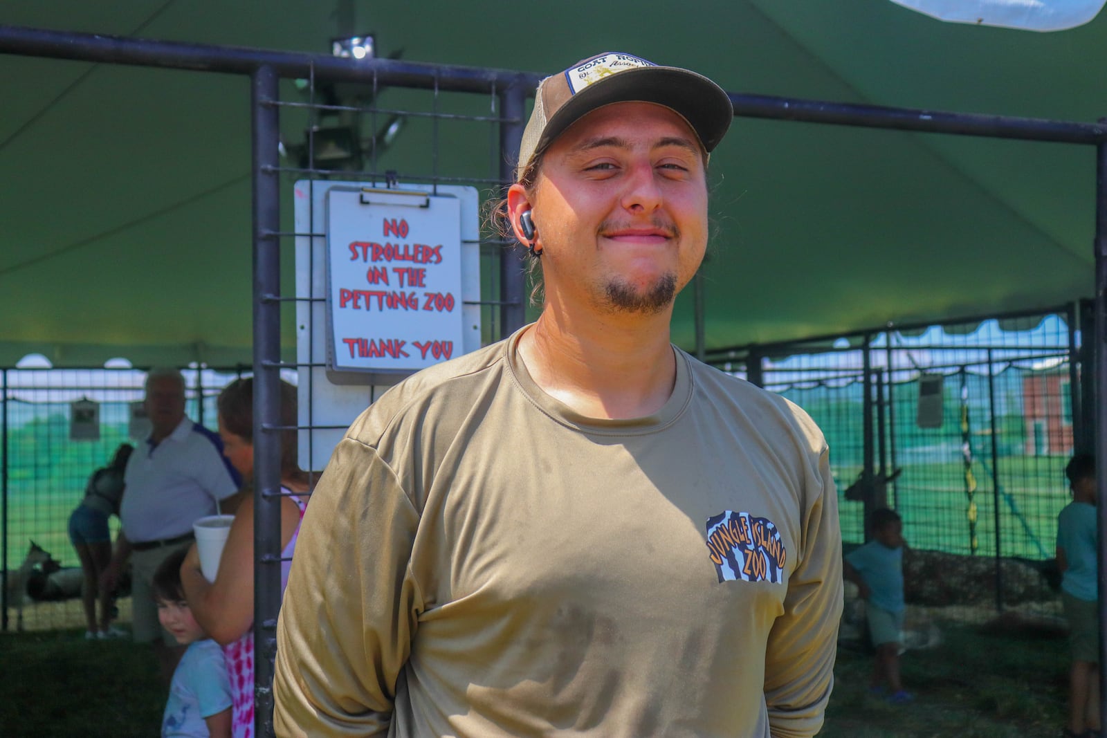Ean Boecker, a member of the Jungle Island Zoo team, standing in front of their mobile petting zoo at the 2025 Montgomery County Fair