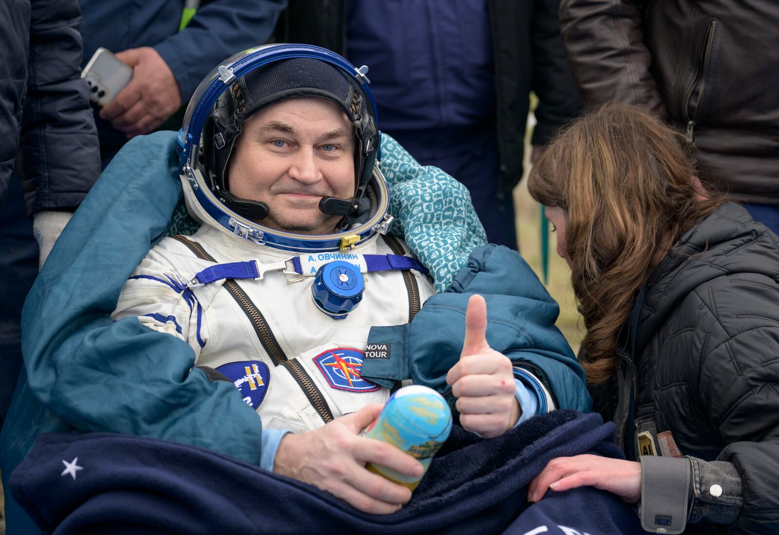 Roscosmos cosmonaut Alexey Ovchinin gestures as he sits outside after landing in a Soyuz MS-26 spacecraft with fellow cosmonaut Ivan Vagner and NASA astronaut Don Pettit in a remote area near the town of Zhezkazgan, Kazakhstan, Sunday, April 20, 2025. (Bill Ingalls/NASA via AP)