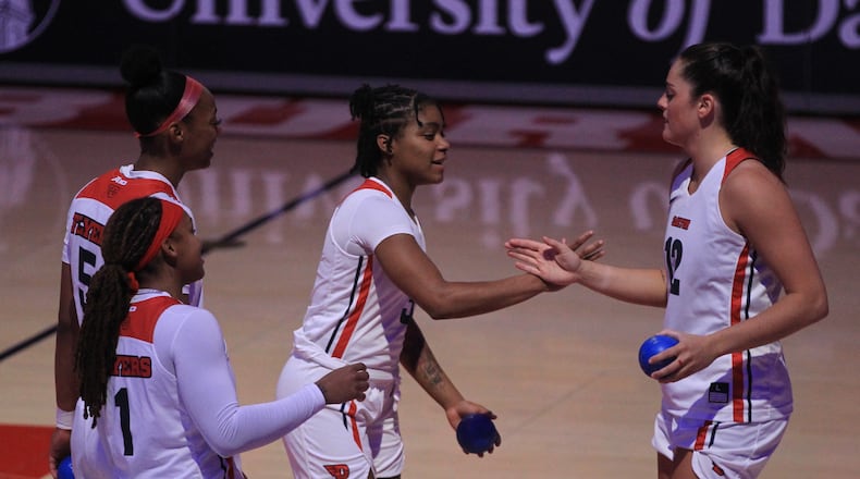 Dayton's starters, including Jenna Giacone, right, and Makira Cook slap hands after being introduced before a game against Toledo on Wednesday, Nov. 17, 2021, at UD Arena. David Jablonski/Staff