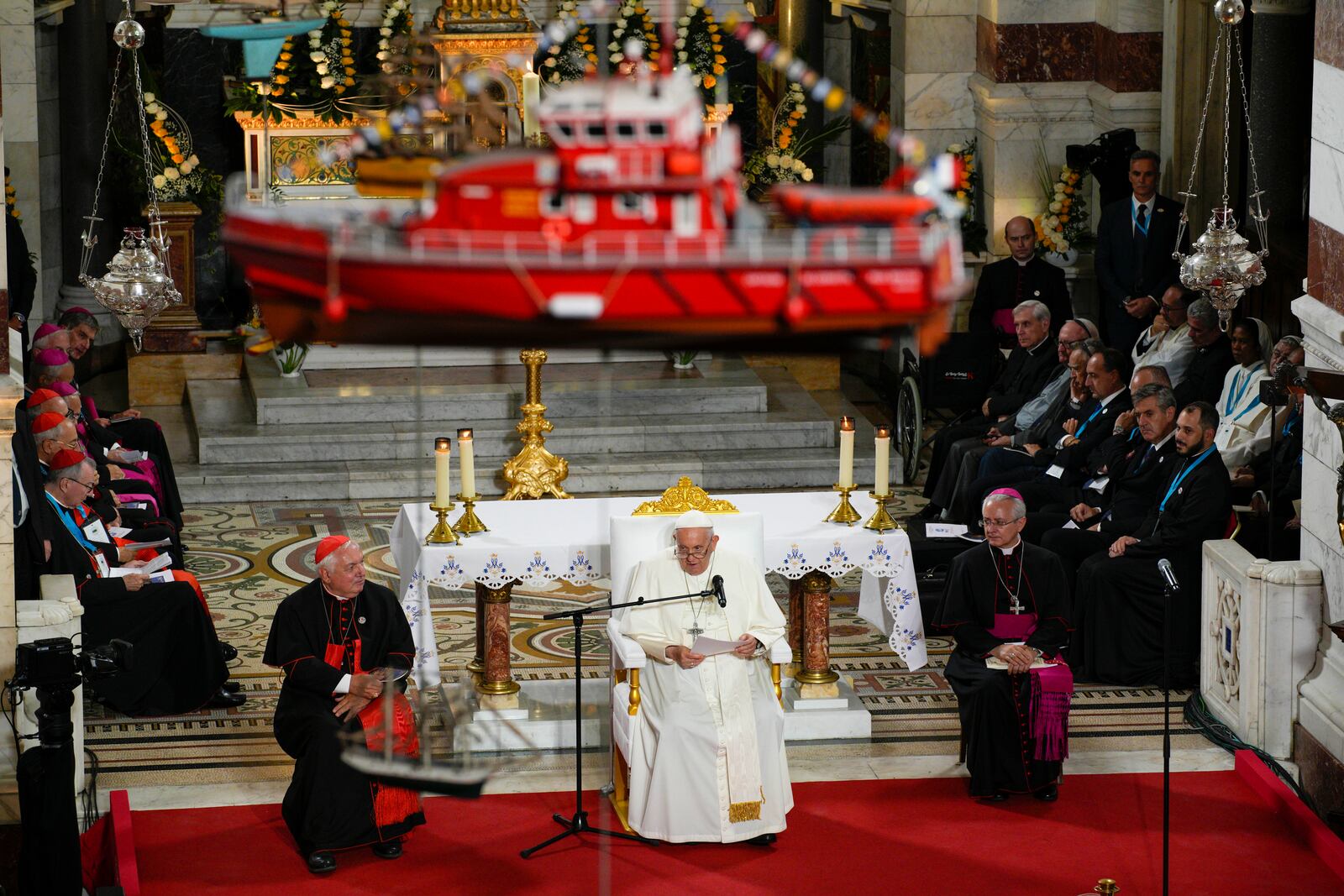 FILE— A model boat hangs from the ceiling of the Notre Dame de la Garde Basilica as Pope Francis delivers a speech in Marseille, France, Sept. 22, 2023. (AP Photo/Daniel Cole, File)