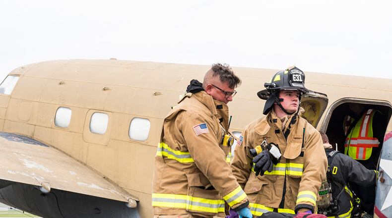 Firefighters from the 788th Civil Engineer Squadron carry a dummy victim to safety on May 5 during a mass casualty exercise at Wright-Patterson Air Force Base. The exercise involved a mock plane crash and gave first responders the opportunity to practice coordinating emergency action procedures. U.S. AIR FORCE PHOTO/JAIMA FOGG