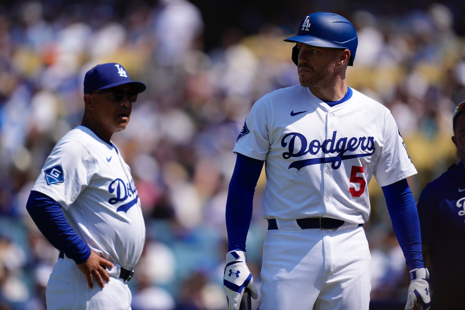 Los Angeles Dodgers' Freddie Freeman, left, walks off the field as manager Dave Roberts stands by after being hit by a pitch during the sixth inning of a baseball game against the Milwaukee Brewers, Sunday, July 20, 2025, in Los Angeles. (AP Photo/Mark J. Terrill)