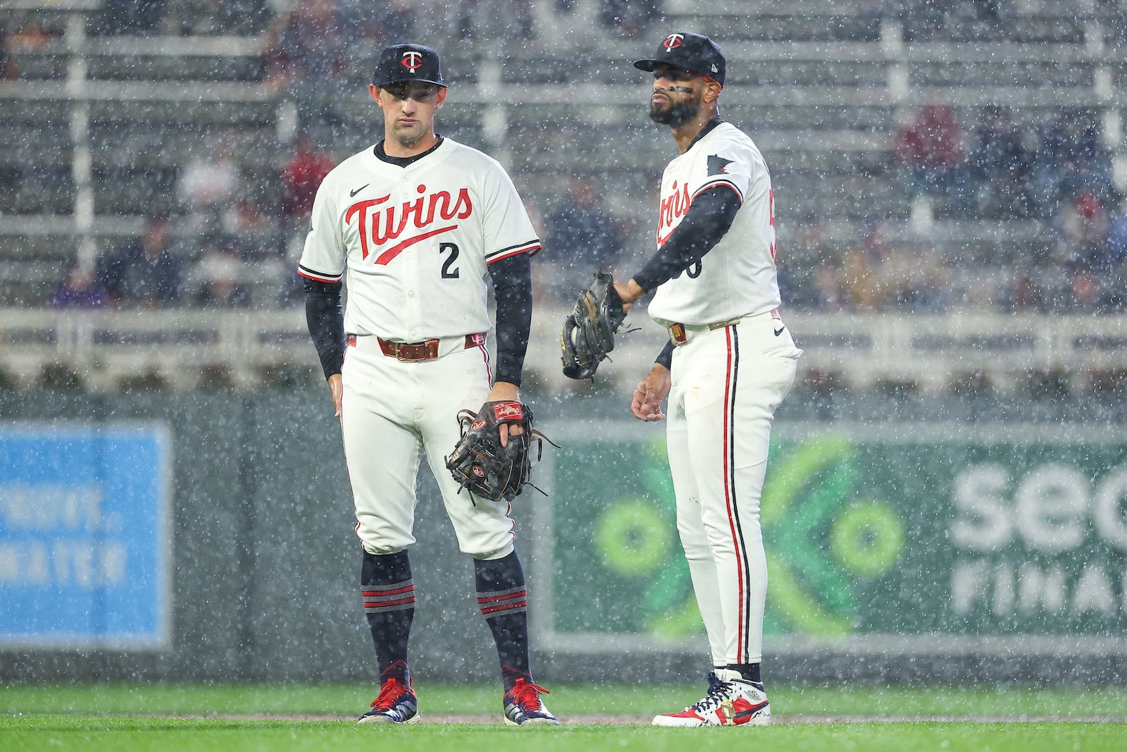 Minnesota Twins shortstop Brooks Lee, left, and second baseman Willi Castro, right, wait in the rain for the fourth inning of baseball game against the Cleveland Guardians, Monday, May 19, 2025, in Minneapolis. (AP Photo/Matt Krohn)