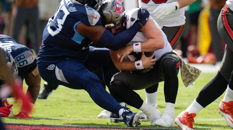 Tennessee Titans defensive tackle Teair Tart, left, sacks Tampa Bay Buccaneers quarterback Baker Mayfield, right, during the first half of an NFL football game Sunday, Nov. 12, 2023, in Tampa, Fla. (AP Photo/Chris O'Meara)