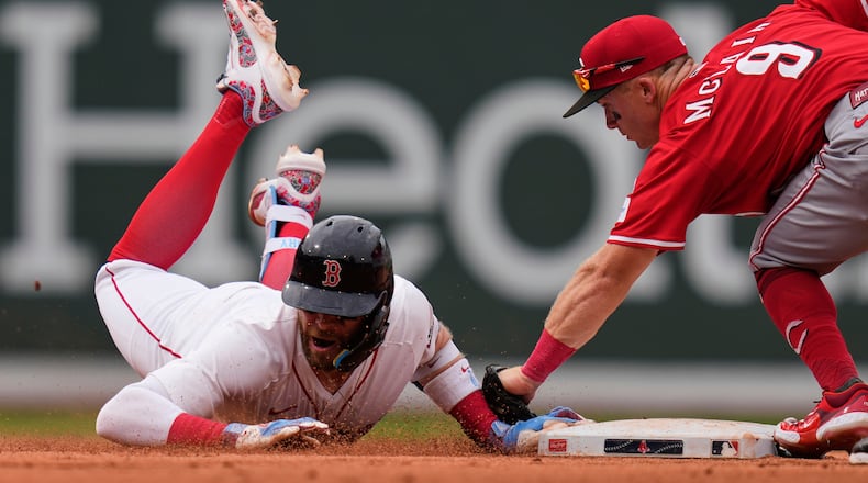 Boston Red Sox's Trevor Story, left, is tagged out by Cincinnati Reds second baseman Matt McLain (9) after over running the base on his RBI double during the eighth inning of a baseball game, a continuation of a game the night before which was suspended due to rain, Wednesday, July 2, 2025, at Fenway Park, in Boston. (AP Photo/Charles Krupa)