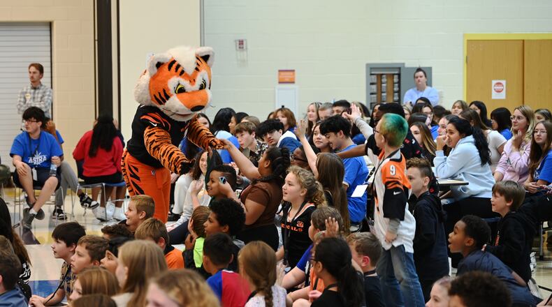 Just a Pair of Shoes, a nonprofit organization that distributes free high-end shoes distributed 120 pairs to students at Highland Elementary School in the Hamilton City School District. The event was sponsored by Kettering Health and the Cincinnati Bengals. After receiving the shoes, the students put them on and tried them out. Pictured is Bengals mascot Who Dey greeting Highland Elementary students before they received a free pair of shoes and three pairs of Bombas socks. MICHAEL D. PITMAN/STAFF