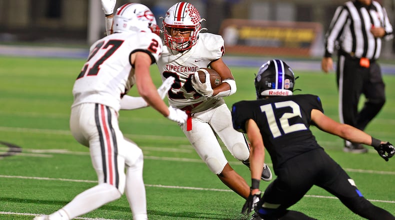 Tipp's Xavier Melton carries the ball against Xenia Friday night. BILL LACKEY/STAFF