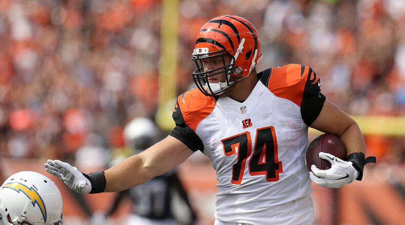 CINCINNATI, OH - SEPTEMBER 20:  Jake Fisher #74 of the Cincinnati Bengals attempts to stiff-arm Eric Weddle #32 of the San Diego Chargers while carrying the ball during the third quarter at Paul Brown Stadium on September 20, 2015 in Cincinnati, Ohio. (Photo by Andy Lyons/Getty Images)