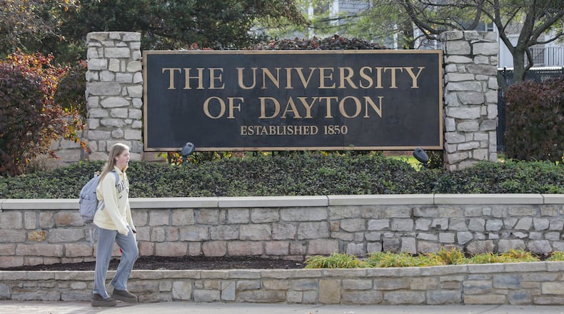 A student walks by a University of Dayton sign at the intersection of Brown and Stewart Streets on Monday, Nov. 24. BRYANT BILLING/STAFF