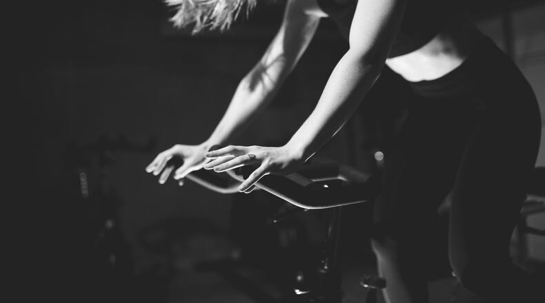 Rinse Cycle owner Kari Carpenter works out on a stationary bike. CONTRIBUTED (Immerse Photography)