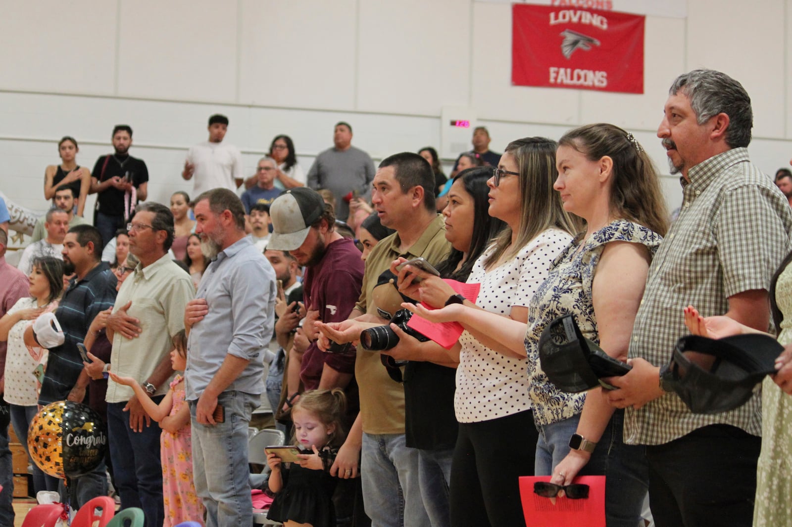 Family and friends recite the New Mexico state flag pledge ahead of a kindergartens' graduation ceremony at the elementary school in Loving, N.M., on Tuesday, May 20, 2025. (AP Photo/Susan Montoya Bryan)