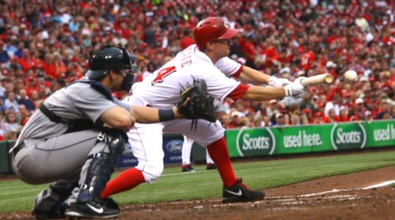 Reds pitcher Mike Leake lays down a sacrifice bunt. The Reds lost 4-2 to the Mariners on Friday, July 5, 2013, at Great American Ball Park in Cincinnati.
