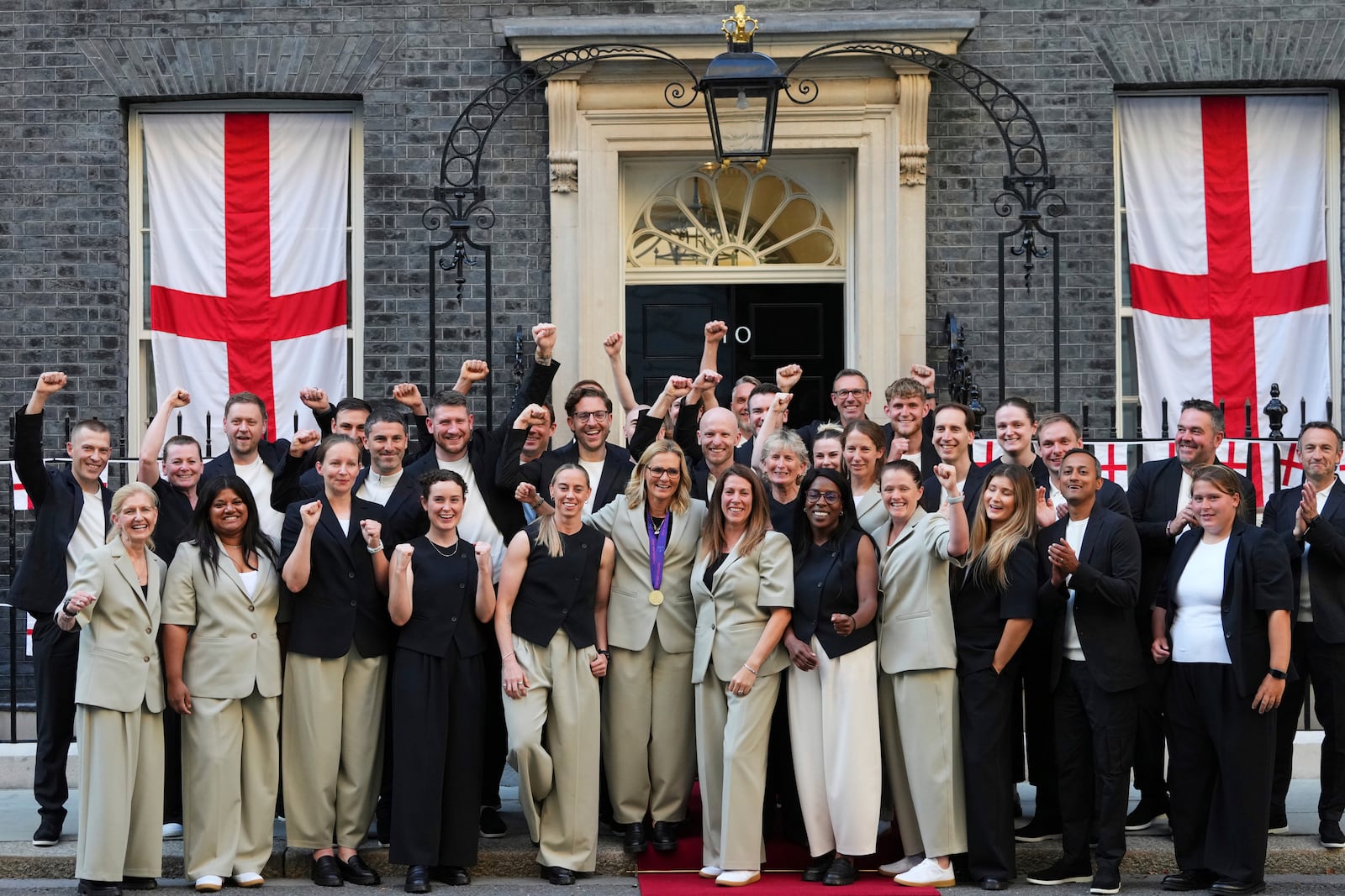 England head coach Sarina Wiegman, center, poses with her staff and England's Football Association president Debbie Hewitt, 2nd left, after leaving a special reception, to celebrate their victory in the Women's Euro 2025 final, at Downing Street in London, Monday, July 28, 2025. (AP Photo/Kirsty Wigglesworth)