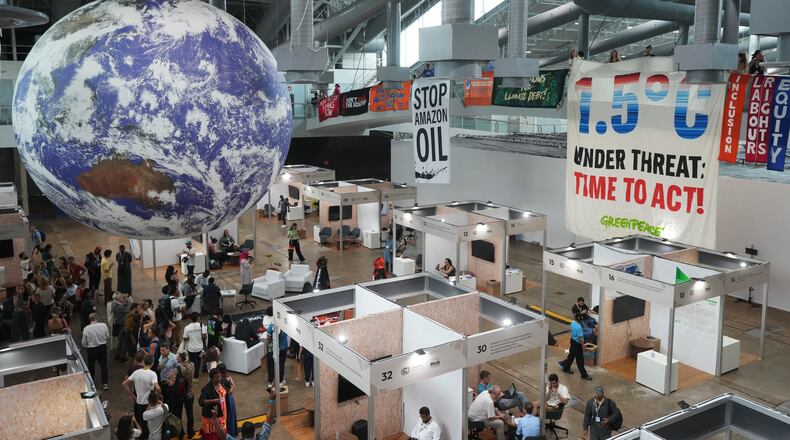 Activists hang banners while participating in a demonstration at the COP30 U.N. Climate Summit, Friday, Nov. 21, 2025, in Belem, Brazil. (AP Photo/Andre Penner)