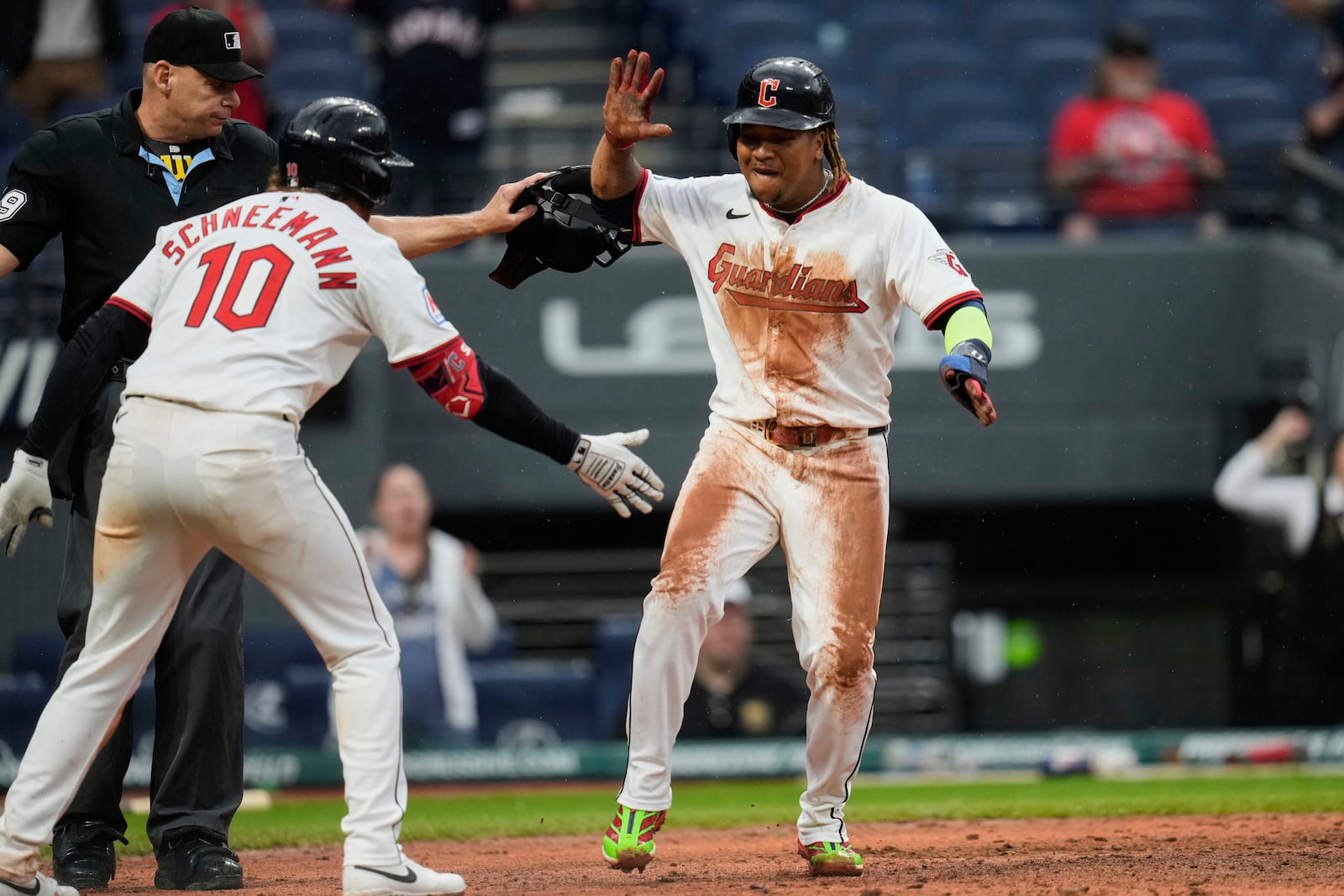 Cleveland Guardians' Jose Ramirez, right, celebrates with teammate Daniel Schneemann (10) after scoring the winning run in the 10th inning of a baseball game against the Minnesota Twins in Cleveland, Thursday, May 1, 2025. (AP Photo/Sue Ogrocki)