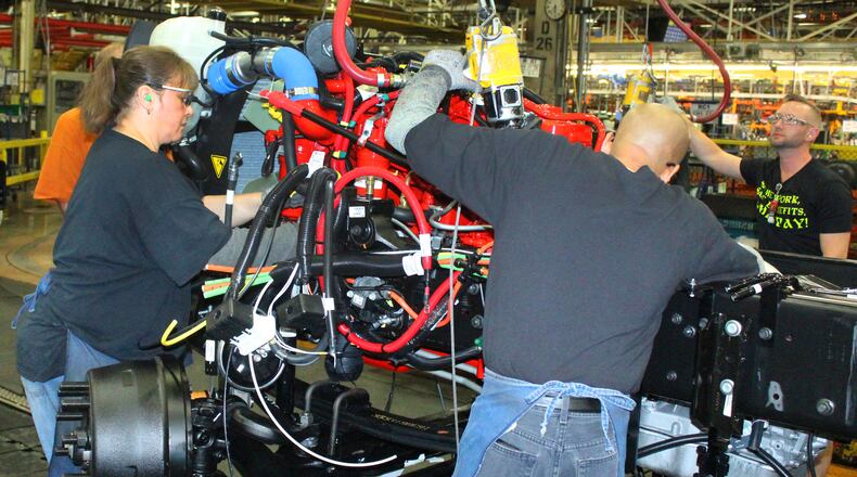 Navistar International employees work on the assembly line putting an engine in a new truck in 2018. The company reported a net loss of $36 million during the first quarter of fiscal year 2020. JEFF GUERINI/STAFF