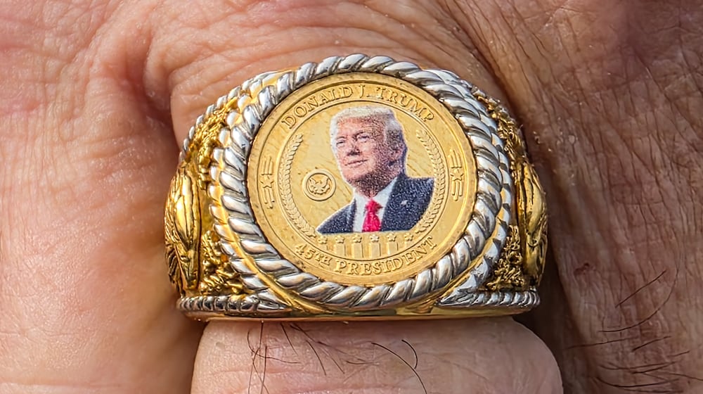 Donald Wenzel shows off is President Trump ring as he waits in line for a Trump rally at Verst Logistics Wednesday, March 11 in Hebron, Kentucky. NICK GRAHAM/STAFF