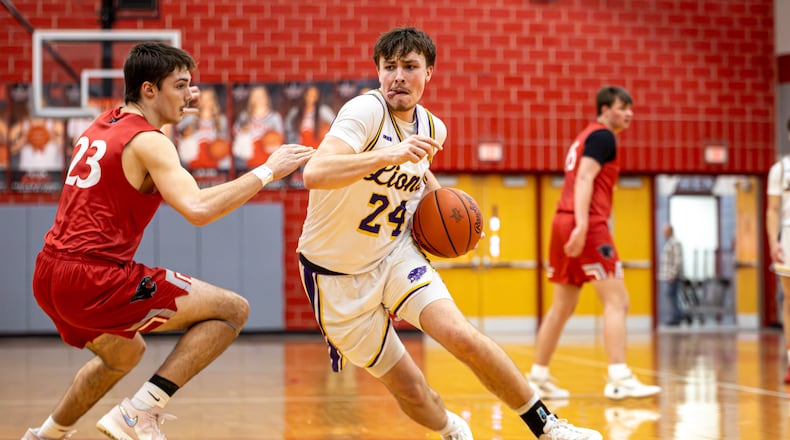 Emmanuel Christian Academy senior Nate Hudson drives past Twin Valley South junior Lucas Barlow boys basketball team beat Twin Valley South in a Division VI district semifinal game on Monday, March 2, 2026 at Troy High School. The Lions won 73-50. MICHAEL COOPER / STAFF