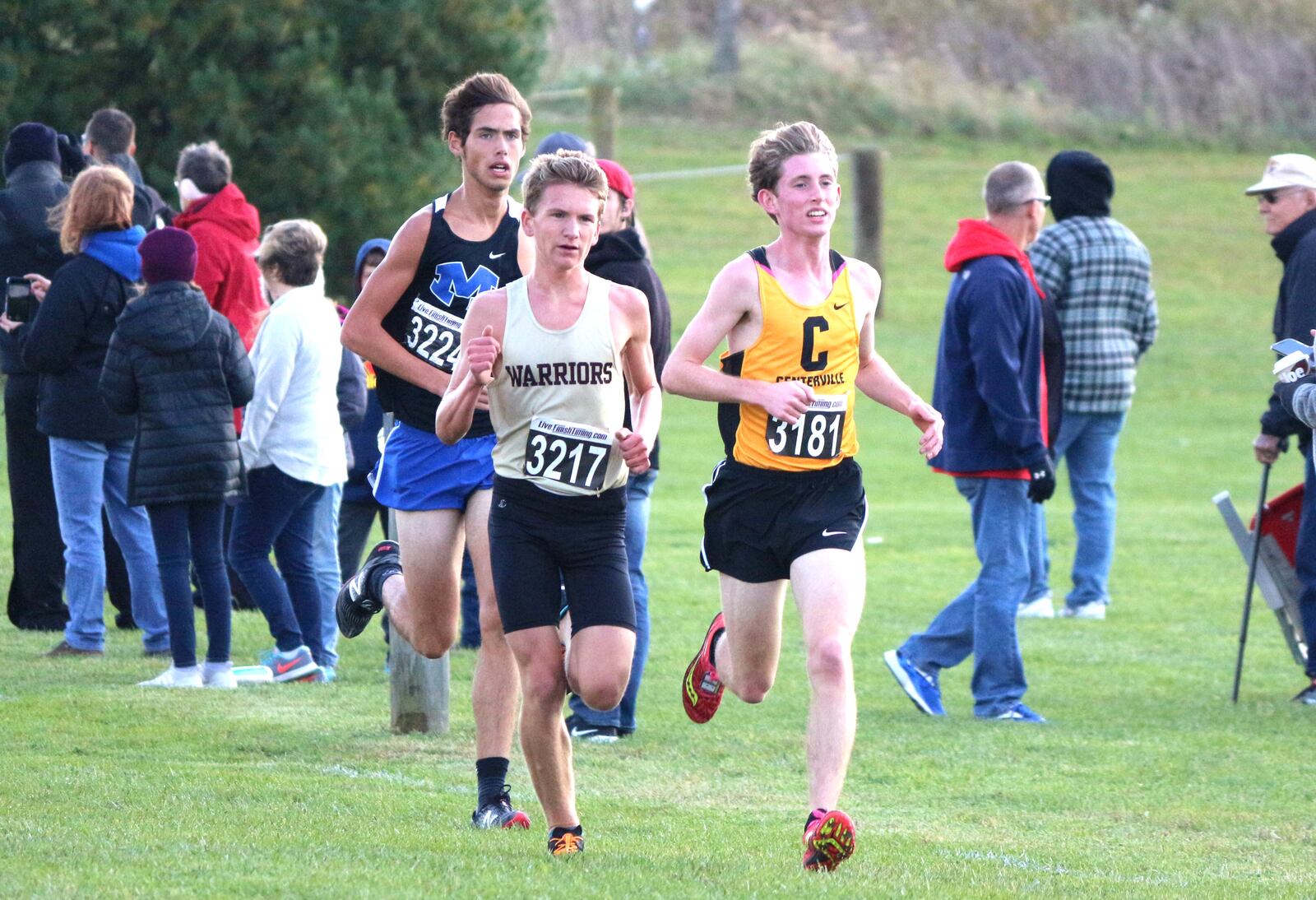 Miamisburg senior and No. 1 runner Parker Hines (3224) keeps pace with Centerville’s Ben Burkett (3181) and Lebanon’s Sam Duncan (3217) during the Division I district championships last Saturday in Cedarville. Hines finished sixth overall to lead the Vikings to their first district title since 1969. Contributed / Greg Billing