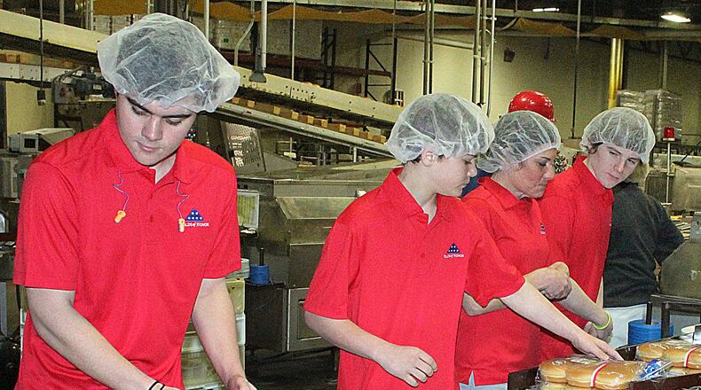 Tricia English and her sons (left) Nathan, Austin and Noah help load bread on racks Tuesday March 20, 2018 to be delivered to businesses in the Springfield area. JEFF GUERINI/STAFF