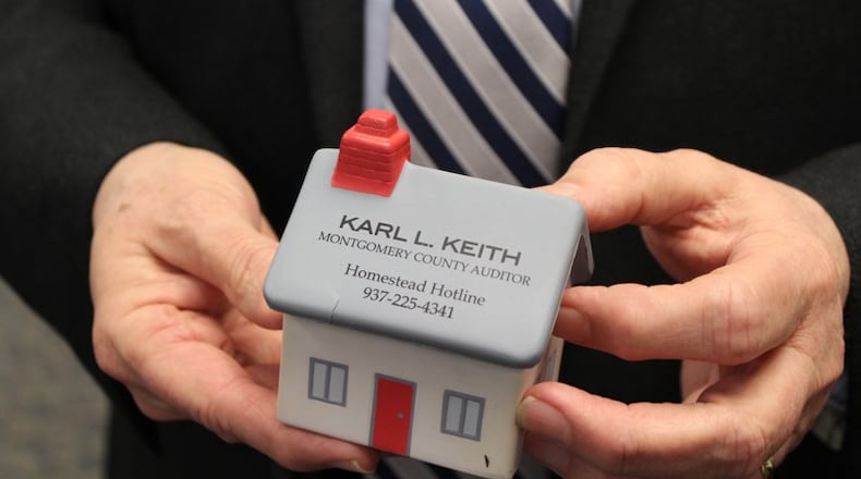 Montgomery County Auditor Karl Keith holds a foam desktop toy with the phone number citizens can call to learn more about the homestead exemption program. CORNELIUS FROLIK / STAFF