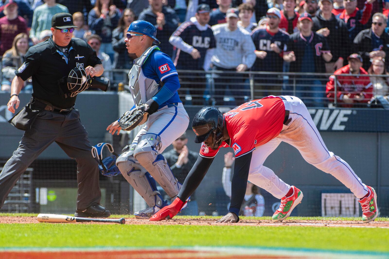 Cleveland Guardians' Jhonkensy Noel, front, scores on a double by Daniel Schneemann off Kansas City Royals starting pitcher Cole Ragans as catcher Freddy Fermin looks for the ball and umpire Cory Blaser watches the play during the second inning of a baseball game in Cleveland, Sunday, April 13, 2025. (AP Photo/Phil Long)