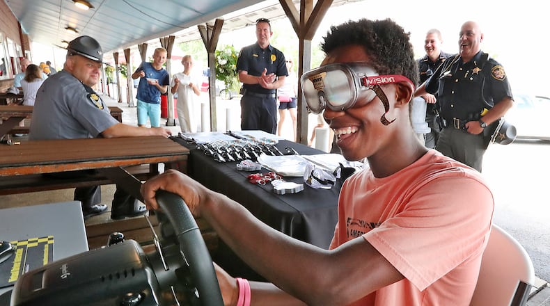 Pierre Bowman tries to operate a driving simulator with a pair of Fatal Vision, drunk goggles, during the 2021 Drive Sober or Get Pulled Over campaign kickoff at Youngs Jersey Dairy. A driving simulator will be in downtown Lebanon on Saturday, Aug. 19, 2023 to kick off the 2023 event in Warren County. BILL LACKEY/STAFF