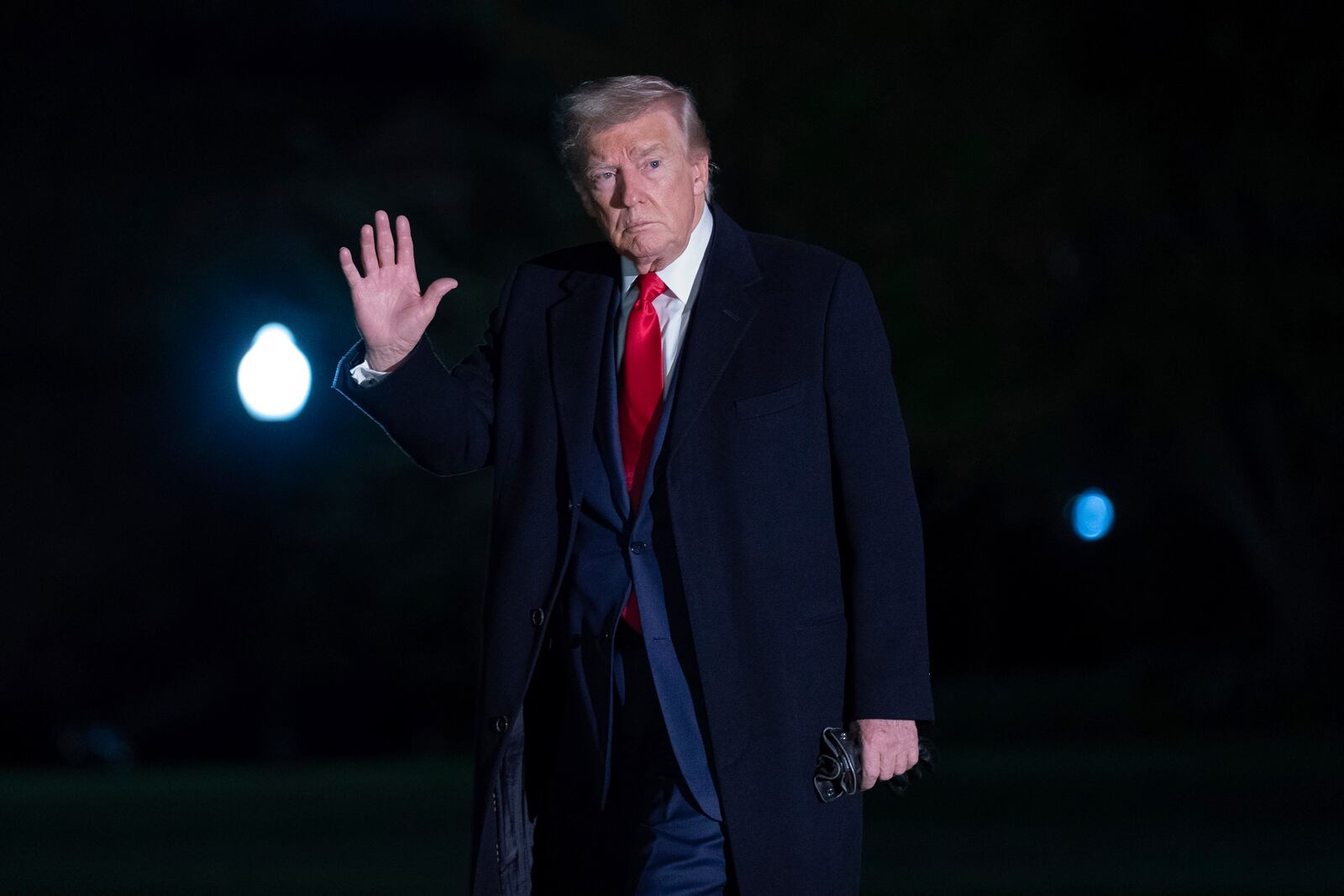 President Donald Trump gestures to reporters as he walks on the South Lawn of the White House in Washington, Sunday, April 13, 2025. (AP Photo/Jose Luis Magana)